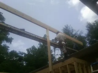 Carpenter setting a ridge beam over a new addition frame — Ice Dam Removal by Roofing Brothers in Dry Ridge