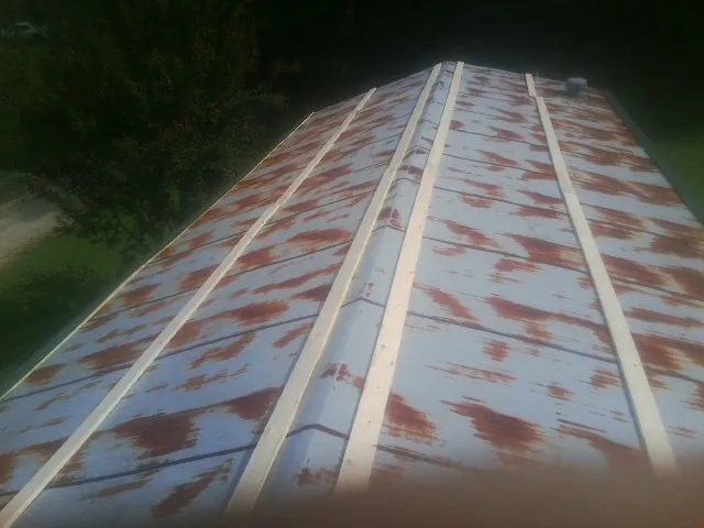 Rusted metal roof panels with new wood purlins before replacement — Storm Damage Roof Repair in Dry Ridge by Roofing Brothers
