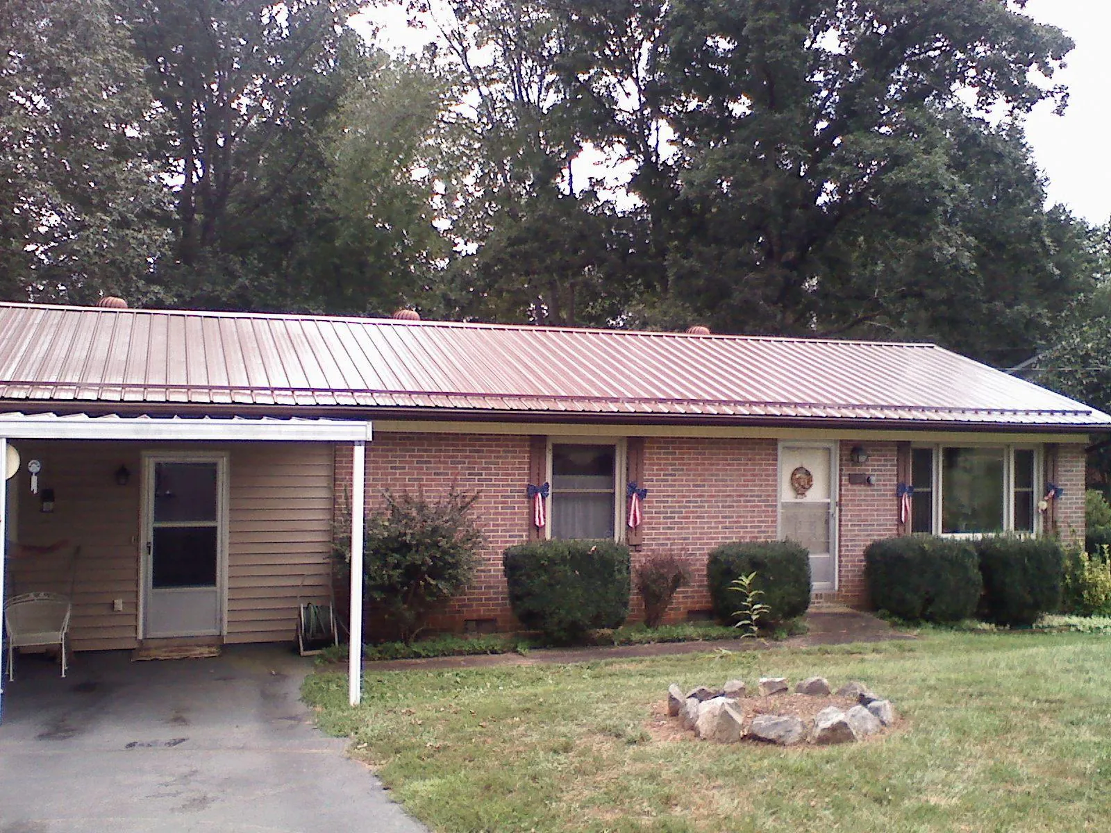 Bronze metal roof and carport on a brick ranch home — Roof Repair work by our crew in Dry Ridge